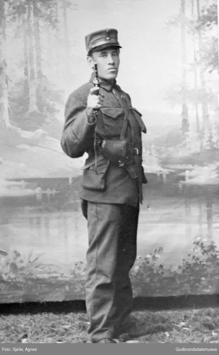 Portrettbilde, ung mann i uniform, Ole K. Holen med revolver.