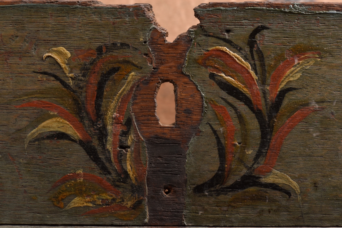 Bemålat fyrkantigt skrin med plant lock av björk och furu. På lockets spegel, med rödmålade lister, är årtalet 1791 och initialerna ISS målade. Skrinet är dekormålat med blommor och blad på grön botten. Skrinet står på fyra svarvade kulformade fötter. Järnsmidda beslag, låsbeslaget saknas.