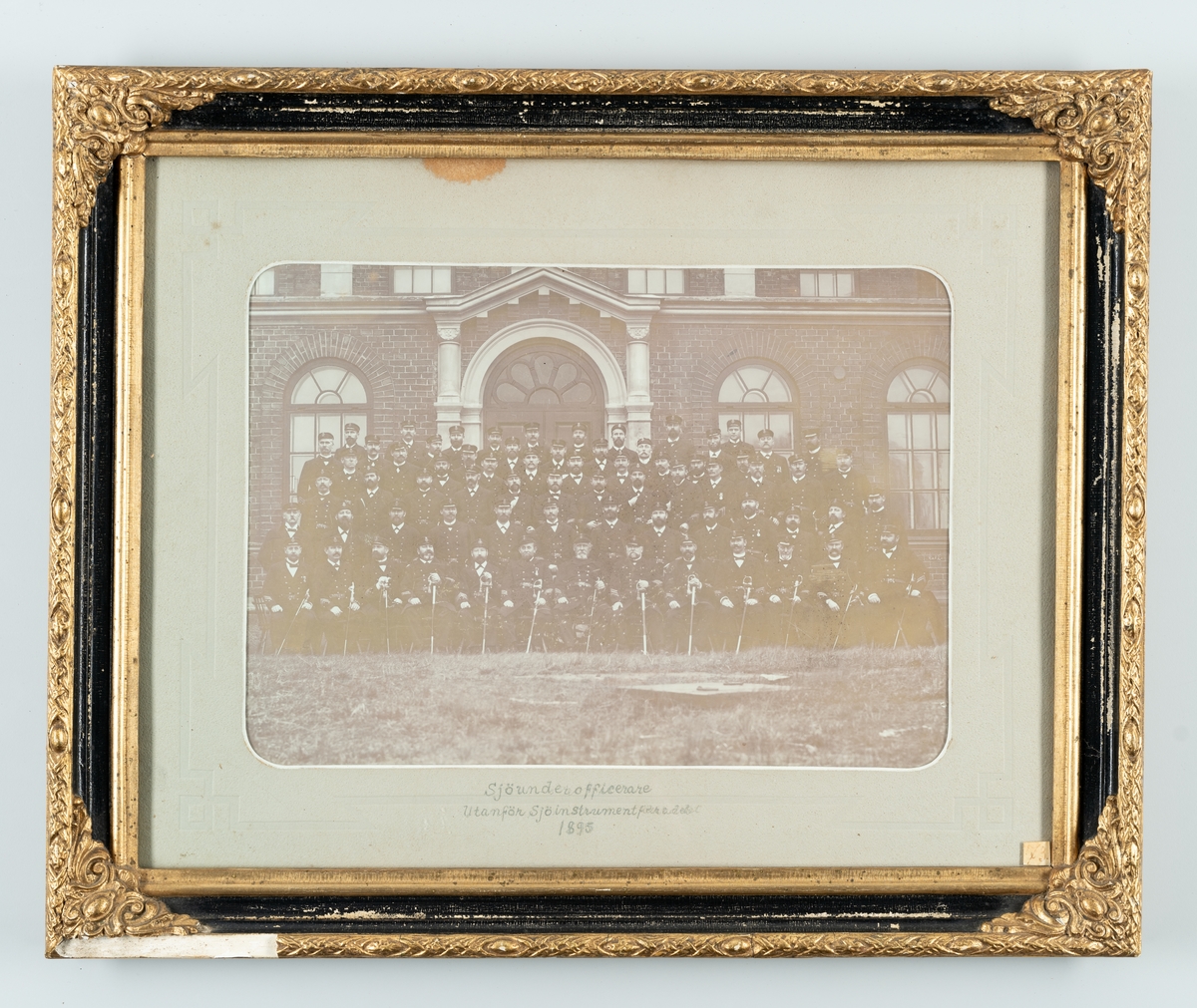 Bilden föreställer en gruppfoto av sjöunderofficerare utanför Sjöinstrumenteförrådet i Karlskrona 1895.