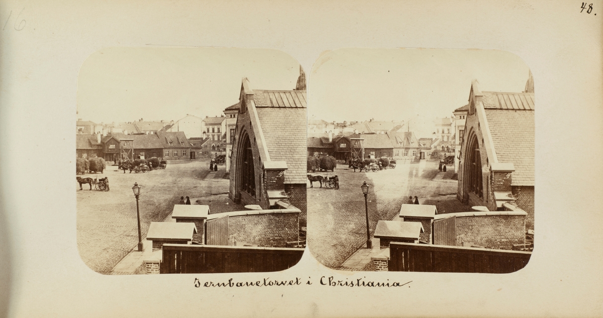 Jernbanetorget i Christiania (Oslo) i 1862. Hester og vogner med høylass venter på tur til høyvekten. Til høyre Christiania stasjon (senere Oslo Østbanestasjon)