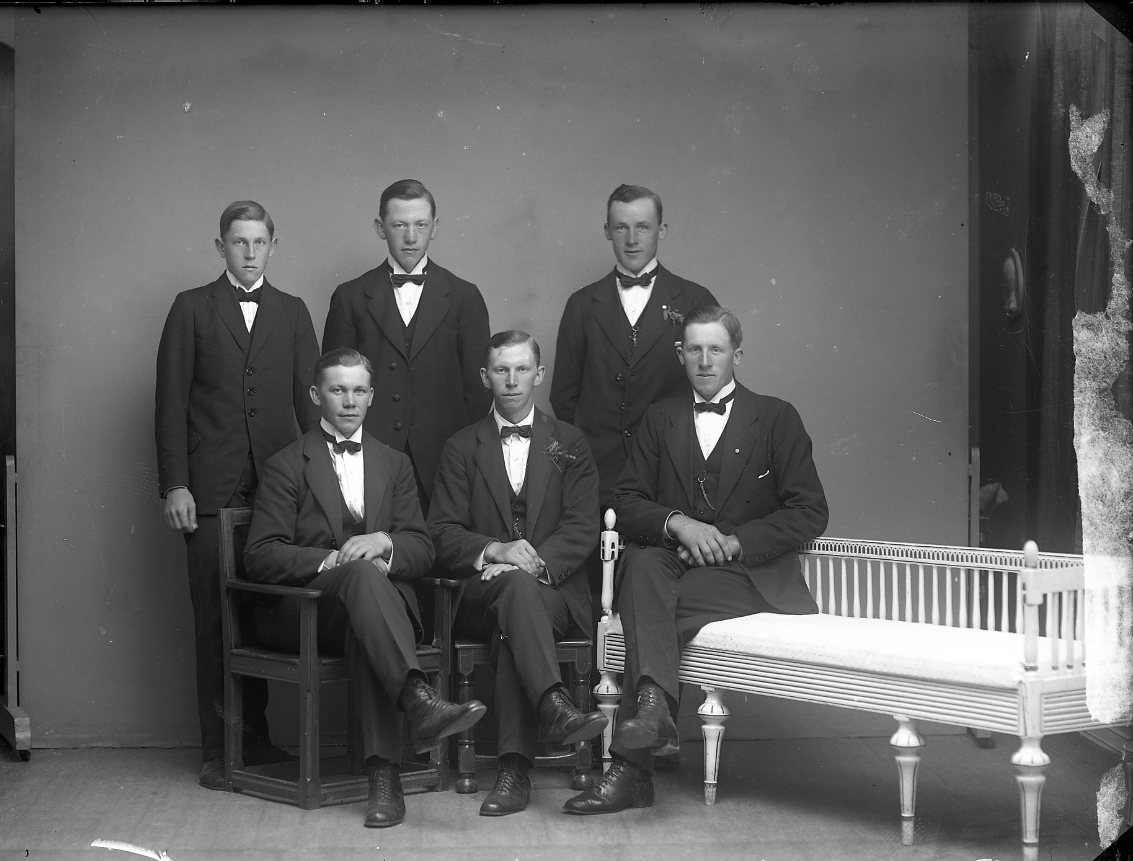 Gruppbild med sex unga kostymklädda män. En av dem är sannolikt Ernst Johansson från Kabbarp. Möjligen i samband med mönstring.
