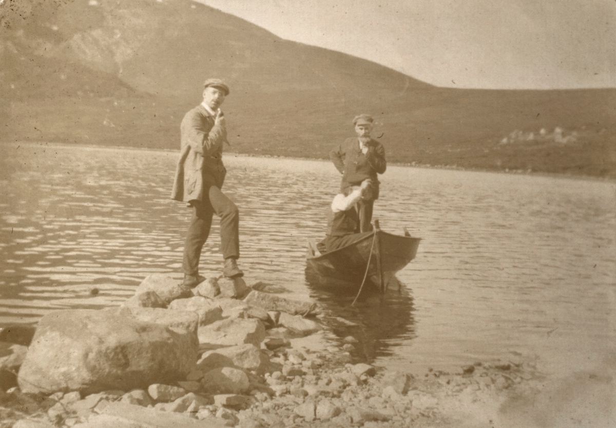 Motiv av tre menn med båt ved Folkestadvatnet.