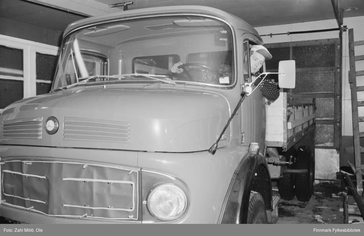 Bildeserie av Ole Zahl Mölö fra 1969 og 1967 av diverse biler. Mercedes_Benz liten lastebil med kort førerhus, fotografert i garasje med en sjåfør bak rattet.  Muligens Trucks L-serien ("the Kurzhauber").