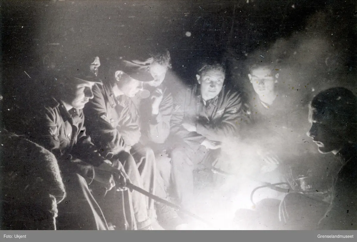 Julaften i mannskapbunkers ved Litzafronten. Juli 1941 - oktober 1944. Soldater i uniform rundt bål med kaffe på kok. 