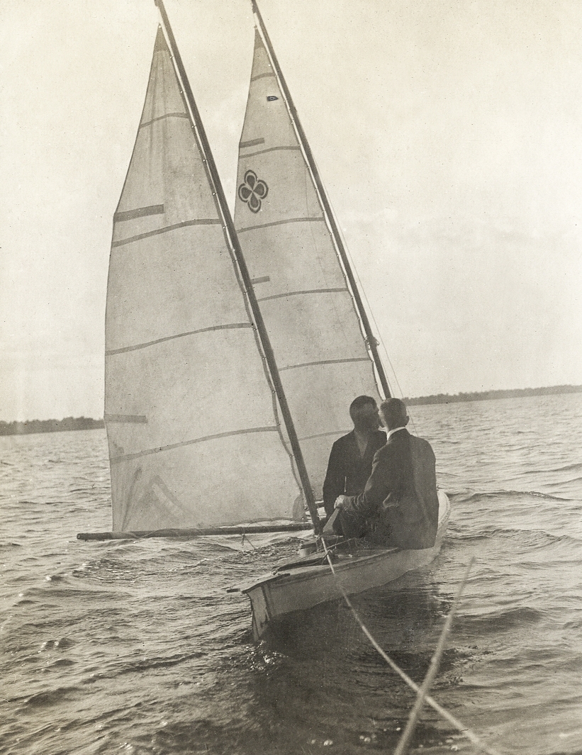 Två män i kostym i en segelbåt.