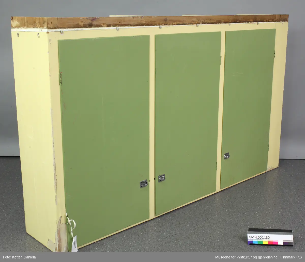 Kjøkkenskapet er et overskap til vegghengt montasje. Dens kropp er malt lysegul. Dørene er malt grønn. De loddredde elementene, men også tak og bunn, er bygget av sammenlimte trebord. Hyllene er føyd inn i noter. Det ble også brukt såkalte bølgespiker for å forbinde skapdeler med hverandre.
Bak hver dør er det tre hyller. To av de nederste hyller er dekket med kontaktplast, mønstret plastfolie som er pålimt. Forsiden av hyllekantene er pyntet med remser av rødt mønstret plast.