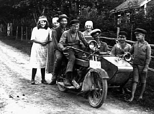 Barn samlade kring man med motorcykel