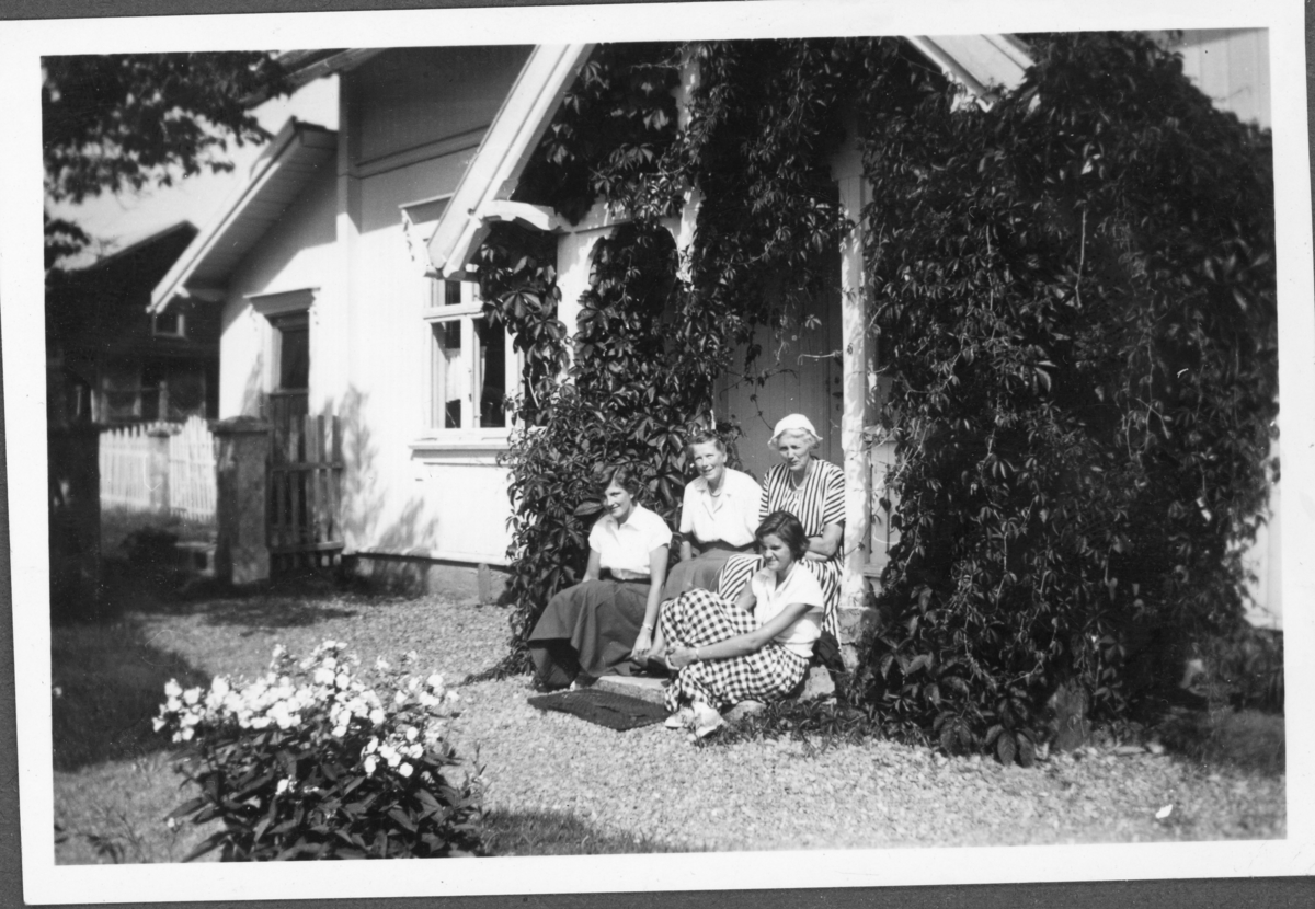Fire kvinner sittende i trapp. Trolig 1950-tall.