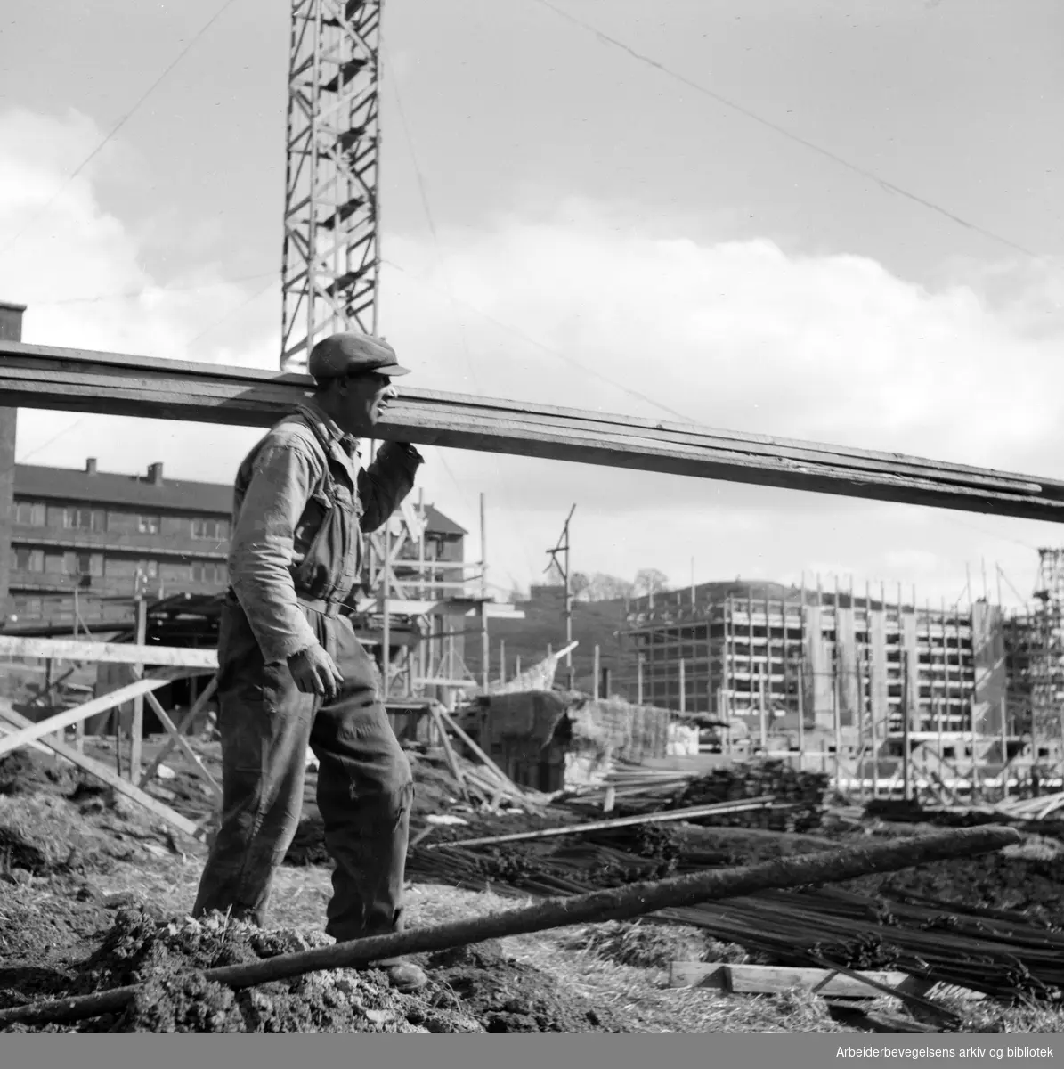 Bygningsarbeider. Bærer planker. Antatt Oslo. 1950 - 1955.