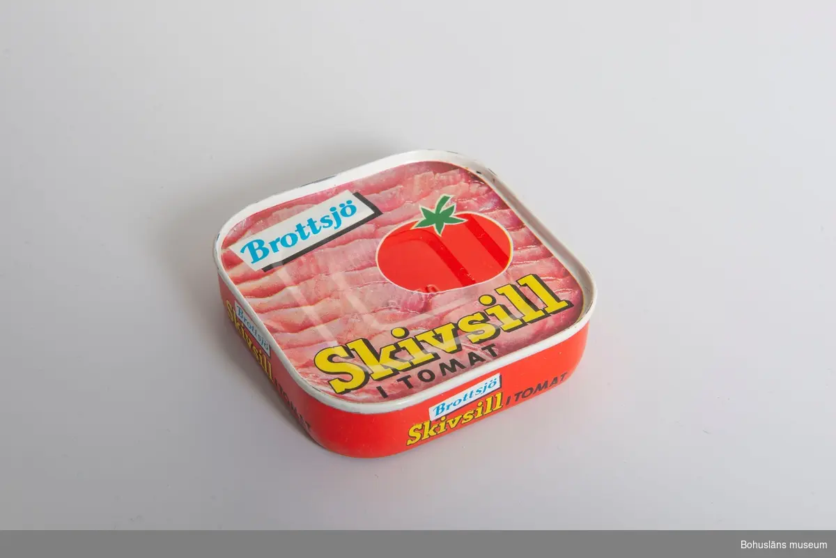 Konservburk "Brottsjö skivsill i tomat". Motiv sillskivor i tomat.
En tomat avbildad.