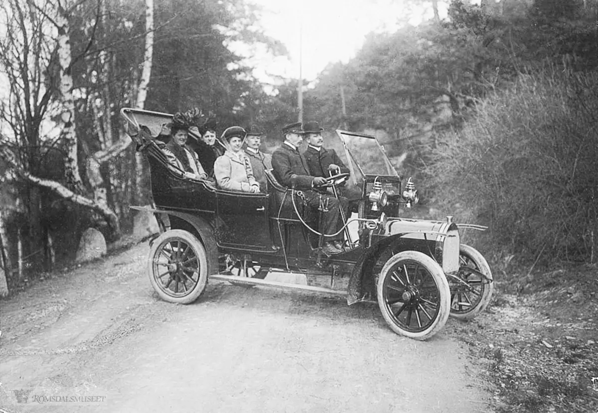Unic på vei opp Romsdalen 1908 med passasjerer..Rutebilen "Unic" på første tur til Romsdal. Johan O Aarø starta rutebiltrafikken med denne bilen 12.05.1908 som den første i Norge med konsesjon.