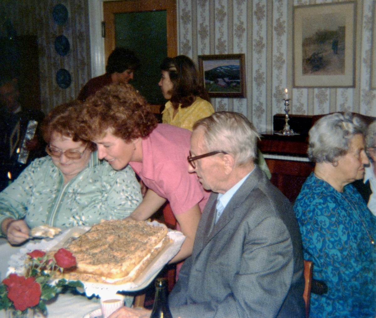 Kokerskan Ingela Sjöberg serverar tårta under en anhörigträff på Brattåshemmet 1979. Från vänster ses Gunvor Olsson (anhörig), Ingela Sjöberg samt Per Pettersson. Relaterat motiv: A1889.