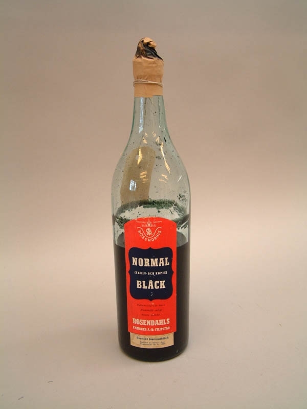 Bläckflaska av klart glas med röd etikett.
Svenskt normalbläck, godkänd av Statens Provningsanstalt för år 1950.