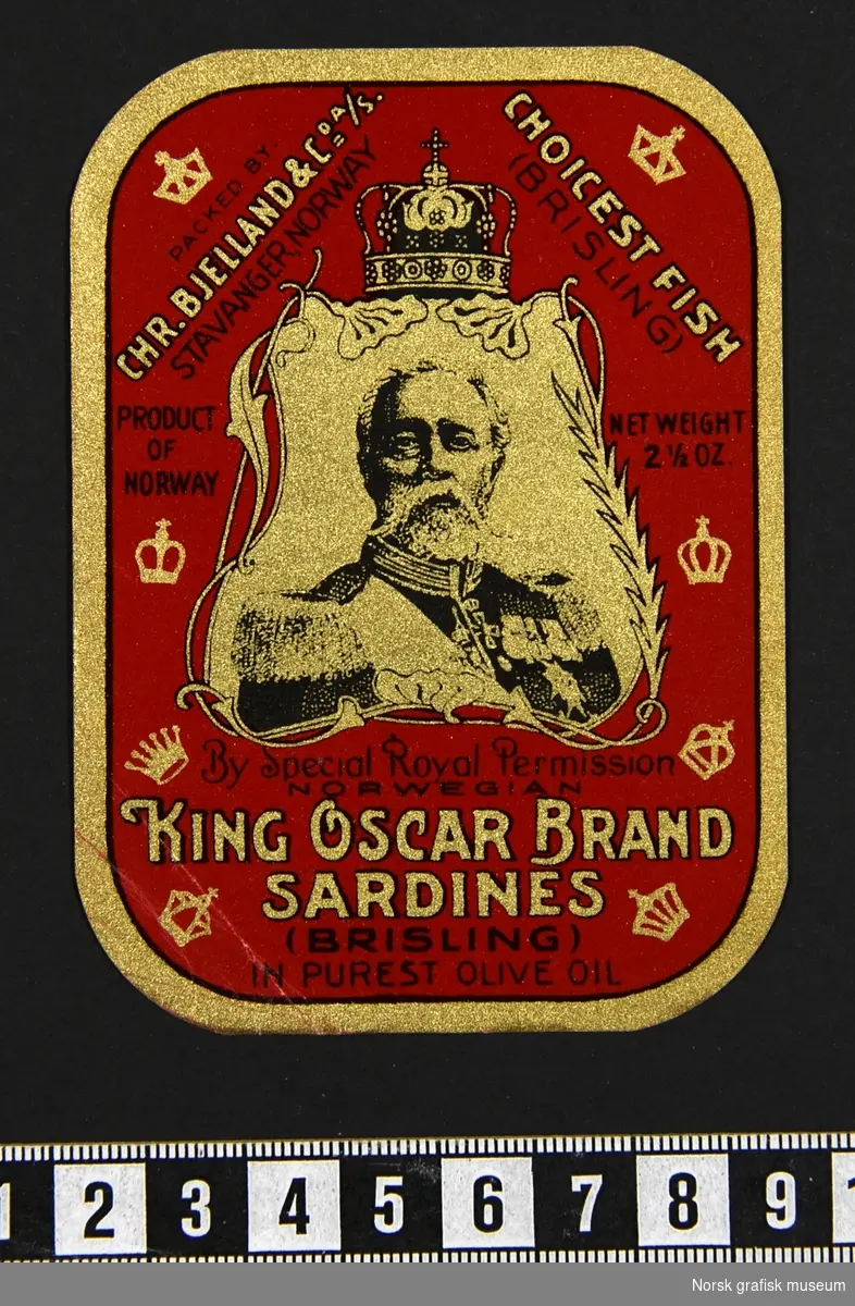 Røde etiketter med detaljer i gull og sort. Sentralt på etikettene er et portrett av Kong Oscar II en en dekorativ ramme rundt. 

"King Oscar brand sardines (brisling) in purest olive oil"