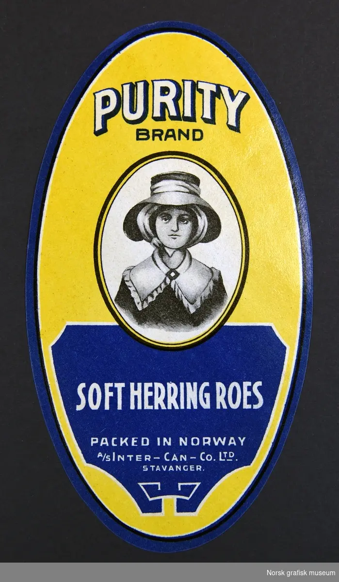 Oval etikett i gult og mørk blått. Midt på er et sort hvitt portrett av en kvinne med hatt. 

"Soft herring roes"
