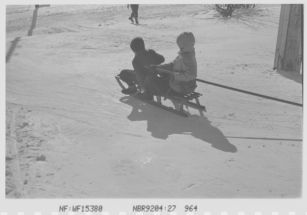 To barn som aker på kjelke. Fotografert 1942.