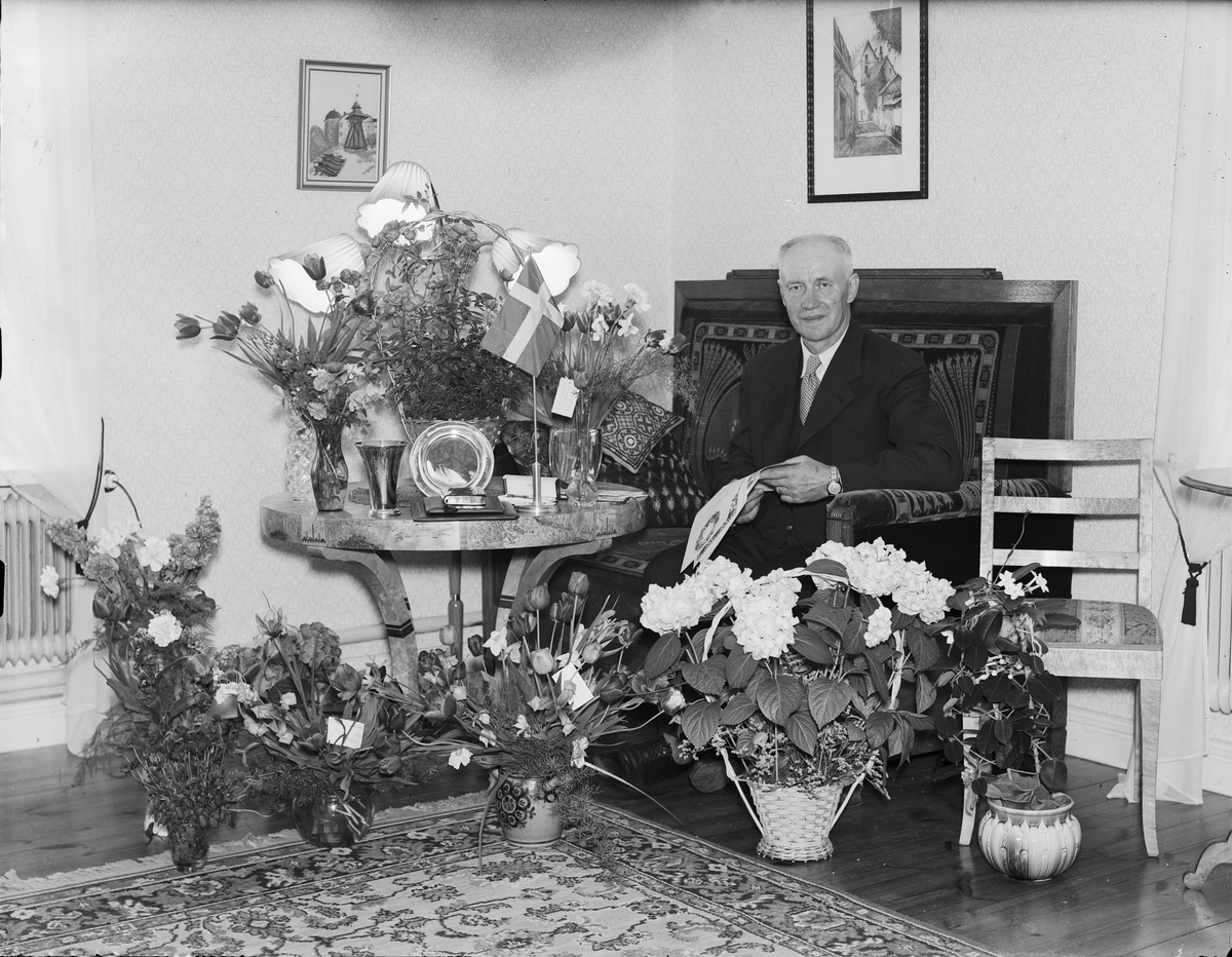 Man i hemmiljö omgiven av blommor, Östhammar, Uppland