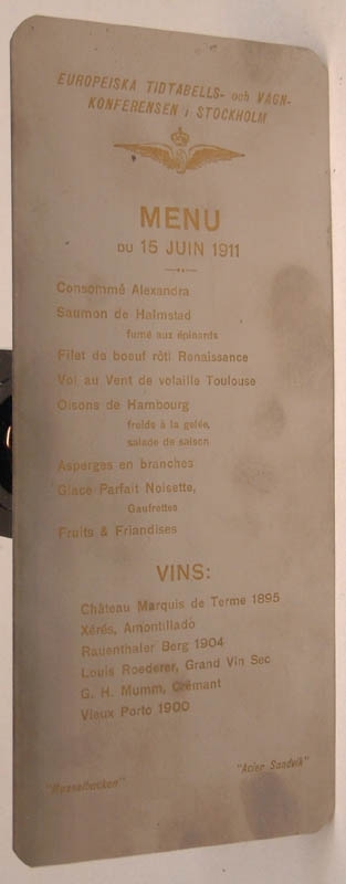 Mat- och vinlista, etsad på rostfri plåt. 8 maträtter och 6 vinsorter på franska.
Text längst upp: "EUROPEISKA TIDTABELLS- och VAGNKONFERENSEN I STOCKHOLM".