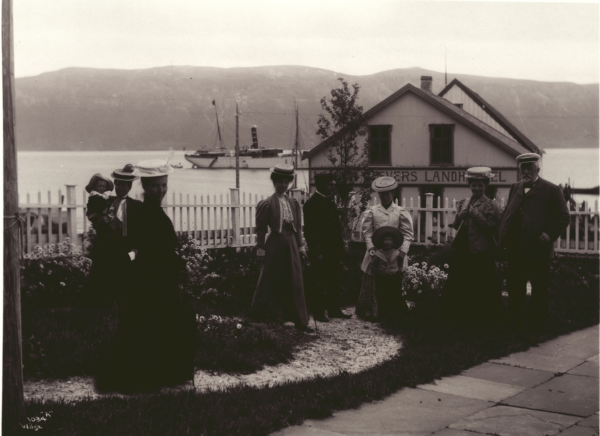 Anton Gjæver med en gruppe mennesker i hagen utenfor hans landhandel i Lyngen i 1907.