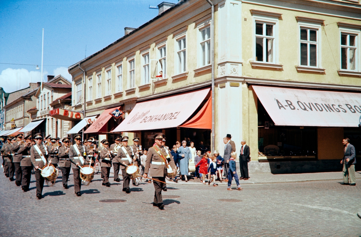 Kronobergs regementes musikkår utanför Quidings bokhandel, 1956. Hörnet Storgatan och Klostergatan i Växjö. Storgatan 12, kv. Klostret 5.