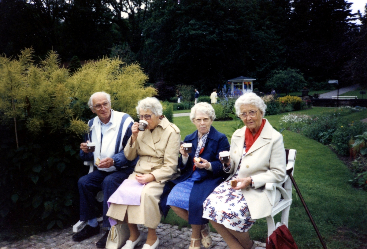 Brattåsgårdens äldreboende är på utflykt till Botaniska trädgården, 1980-tal. Från vänster: Göte Olofsson, Rut Göransson, Valborg Nilsson och Hulda Olsson sitter på en bänk och dricker kaffe.