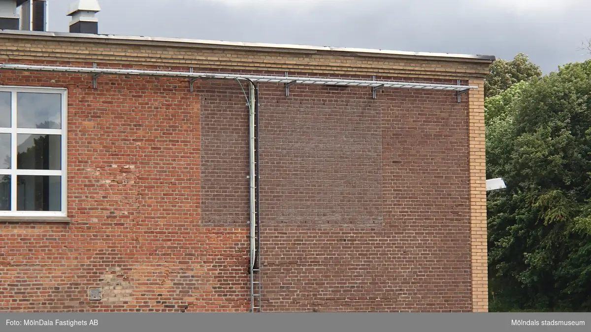 Byggnad 26 på Forsåkersområdet i Mölndal. Fasad mot väster, hörn mot söder. Byggnaden tillhörde tidigare bland annat pappersbruket Papyrus. Fotografi taget i juni 2018. Byggnadsdokumentation inför rivning.
