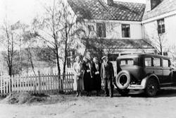 Fire personer står ved en bil foran Fochsengården på Borkene