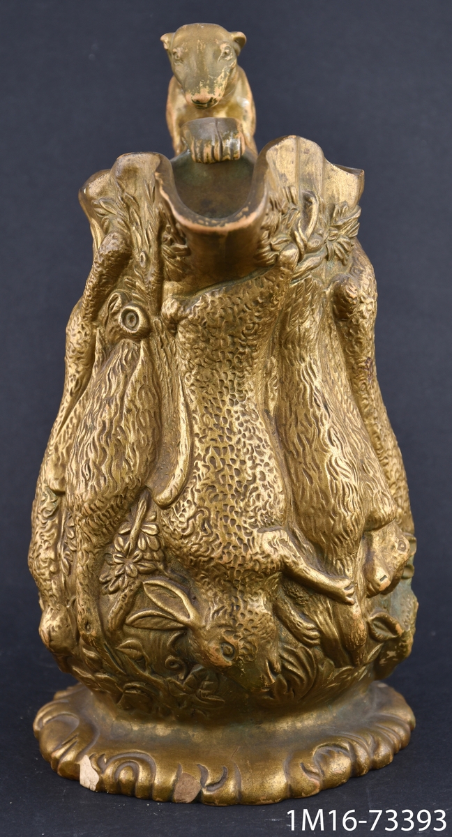 Toddykanna efter engelsk förebild, av  lergods, runtom hängnade djur kroppar i relieff, handtaget i form av en hund.