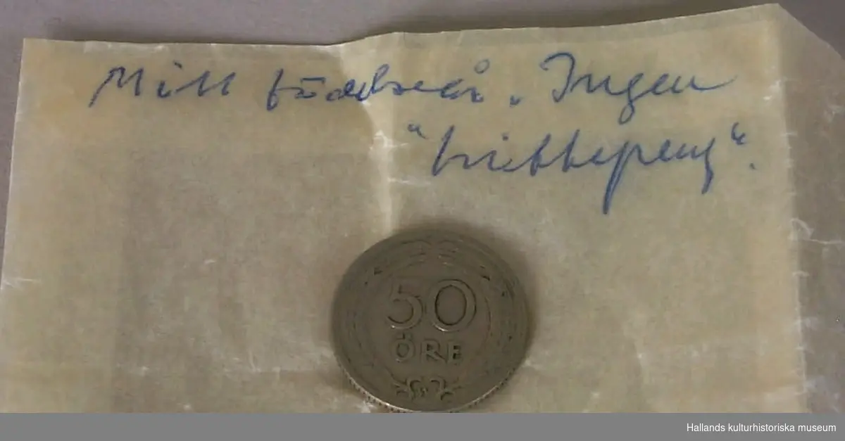 Honungsburk innehållande samling av diverse mynt i valörerna 1 öre till 1 krona (46 st), (övervägande svenska mynt, men också danskt), invikta i olika papperslappar och trycksaker, med anteckningar om tid och plats för upphittandet (39 stycken invikningar). Ett antal av mynten ligger separerade i en mindre blå börs. Ett mynt (enkrona fr. 1949) utan pappersanteckningar. Ett mynt med påskriften: "Mitt födelseår. Ingen 'hittepeng". "(femtioöring fr 1921)". Tre papperslappar utan mynt, men med anvisningar för samlingens hanterande.