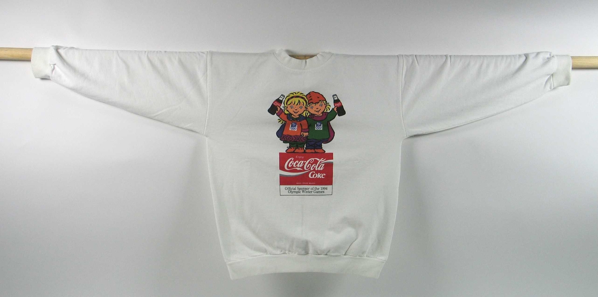 Genser med hvit som hovedfarge i størresle M. På fremsiden er det en  Coca-Cola-logo. Logoen er tilpasset de olympiske vinterleker på Lillehammer i 1994. I logoen er også maskotene for de olympiske vinterleker på Lillehammer i 1994, Kristin og Håkon, representert.