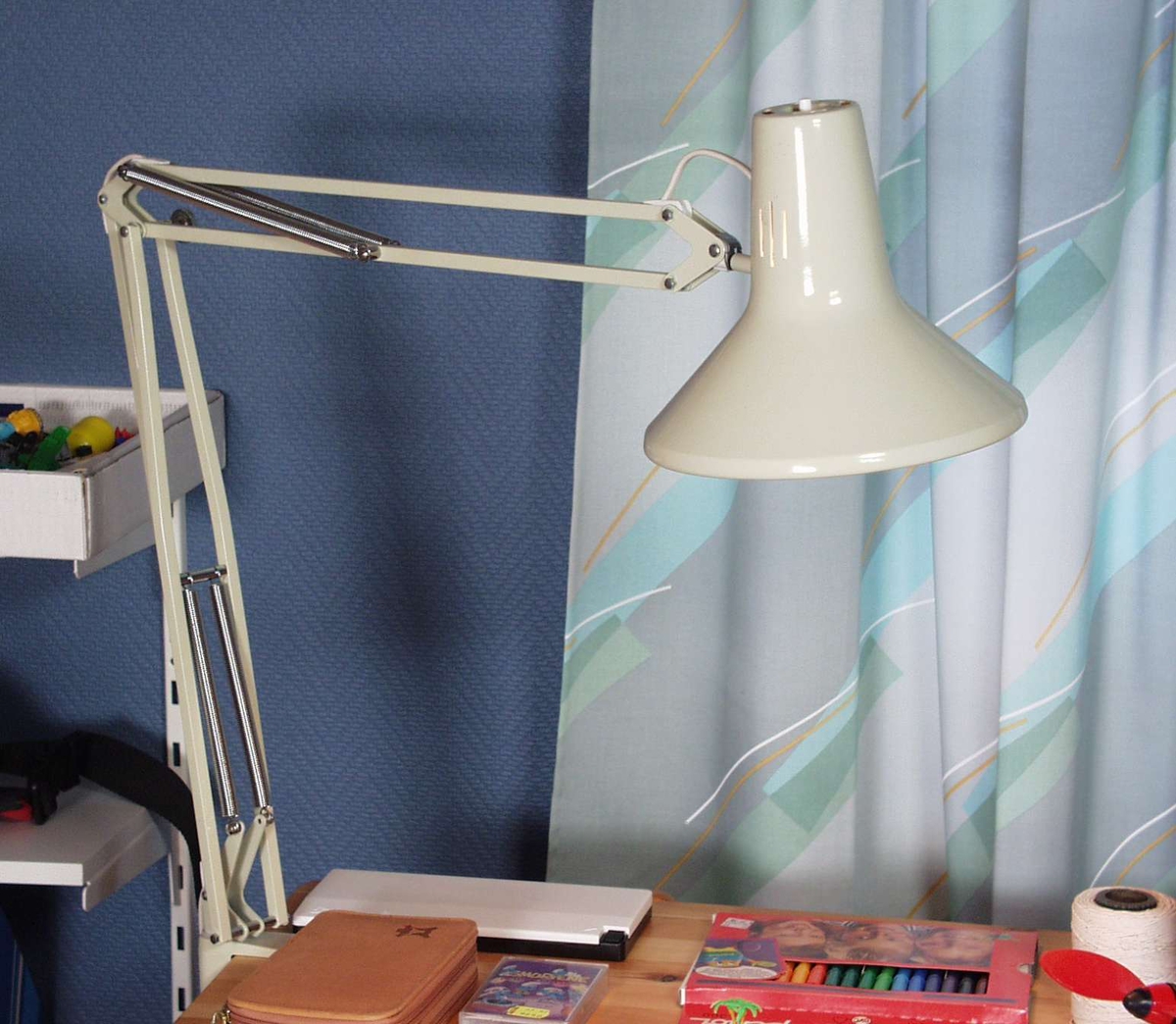 Grålakkert skrivebordslampe i metall med justerbar arm.
