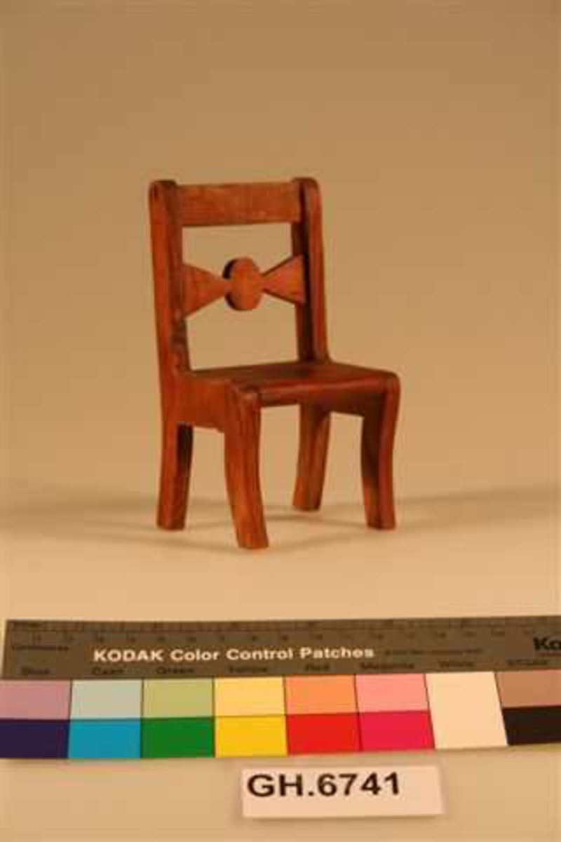 Enkel stol med rett rygg. En tverrsprosse med utbukning i ryggen. Minner om enkle møbler i biedermeierstil.