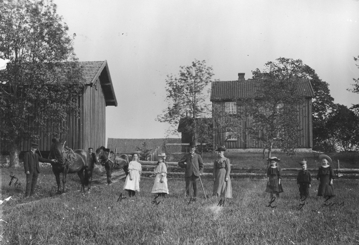 Sundby Østre. Familie samlet på jordet med hester.