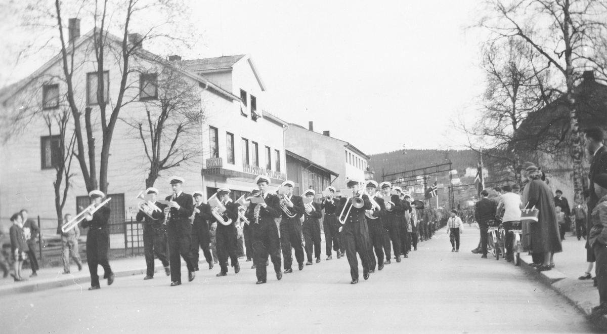 Musikkorps marsjerer  inn i Lillestrøms gater.