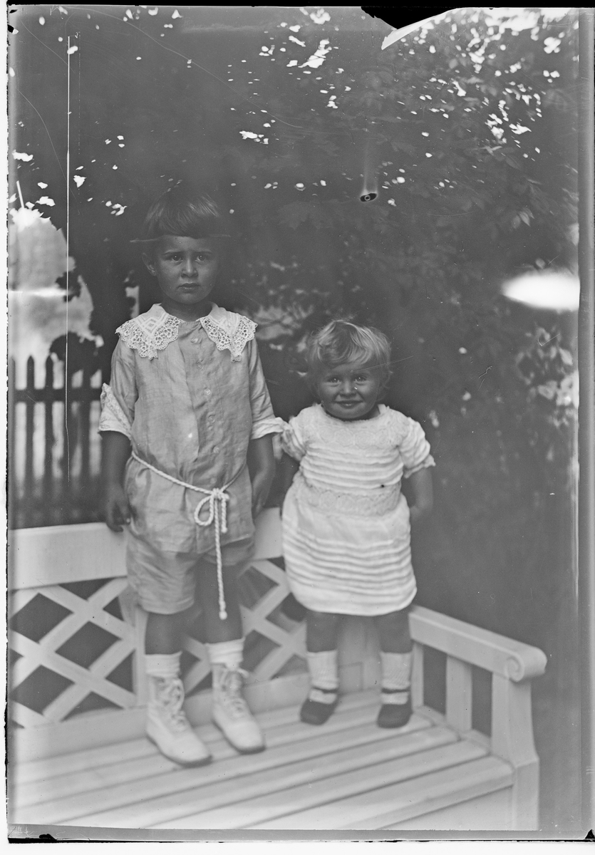 To barn barn står på en benk.
