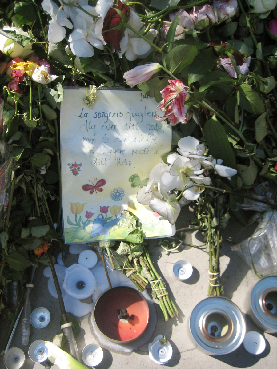 Minner etter terrorhandlingen den 22. juli 2011. Blomster, kort og lykter ved Havgutten på Lillestrøm torg.