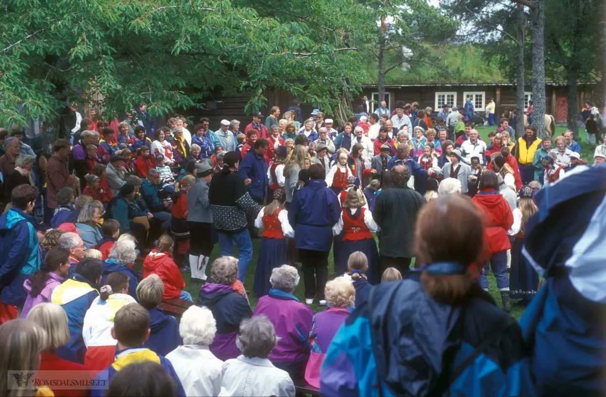 Olsok på Romsdalsmuseet i 1996. .Aktører fra Vistdal bondekvinnelag..Hammervoll-stua og Kleivestabburet i bakgrunnen.