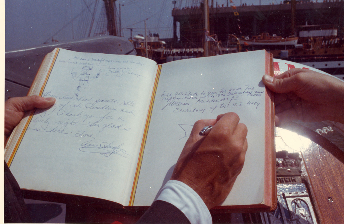Oslo-kl.- fregatt KNM "Trondheim" får besøk av Secretary of the Navy J. W. Middeldorf i New York, sommeren 1976. Mr. Middeldorf signerer i offisersmessens gjestebok.