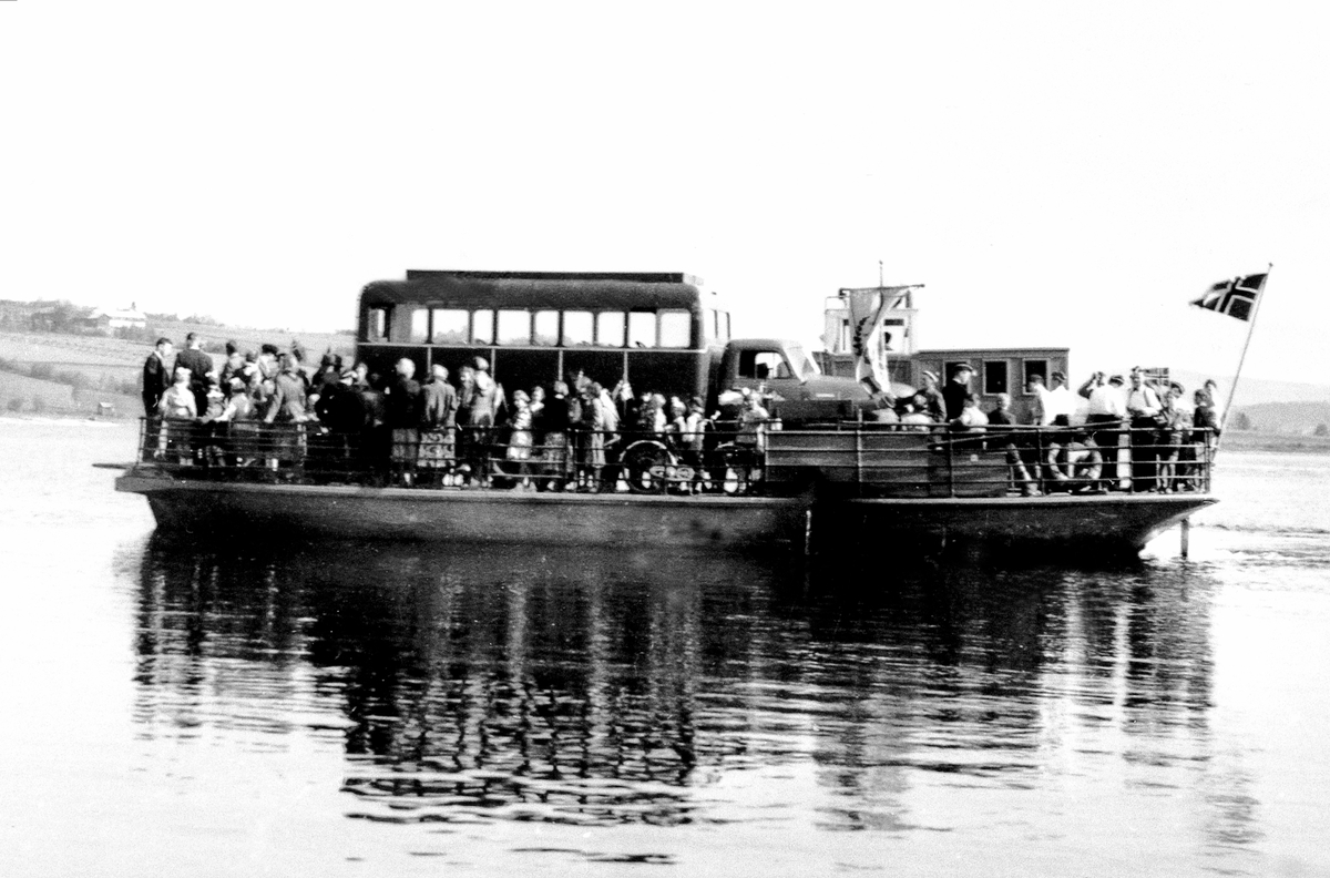 M.F. Helgøya fullt av folk og bil for 17.mai feiring. På vei fra Sundsbrygga på Helgøya. Trolig Chevrolet lastebil 1949-53 påmontert "busshus".