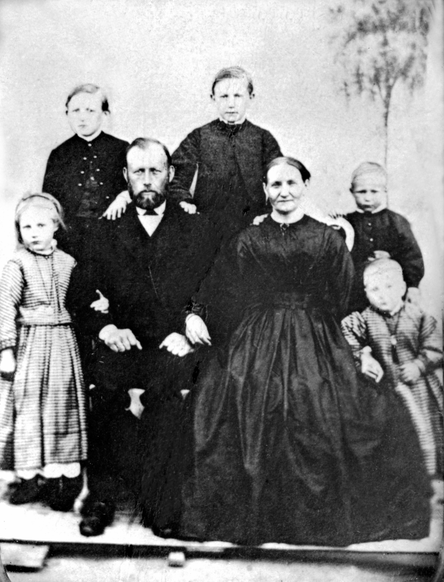 Jacob Olsen Lie (1832-1918) og Juline Mortensdatter Lie (1830-1911) med fem av sine barn. Dette er trolig Karl Sigvard (1859-1907), Ole Martin (1857-1933), Morten (1864-1878), Berthe (1862-1935), Syverine (1866-1923). Helgeby, Nes, Hedmark.