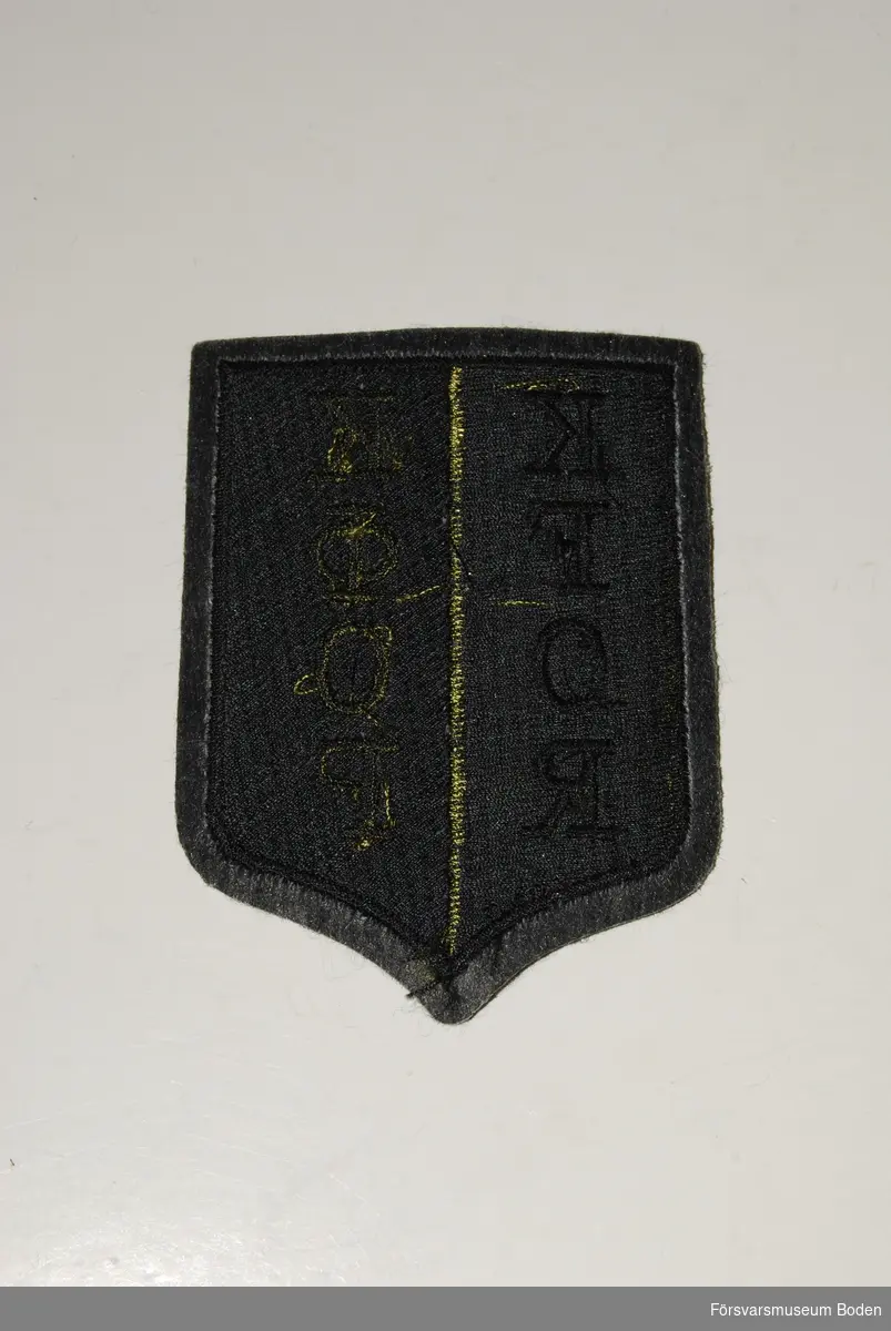 Broderat textilmärke, svart och olivgrönt. KFOR står för Kosovo Forces och är även skrivet med kyrilliska tecken. Märket bars av fredsbevarande enheter i Bosnien 1999-2007.