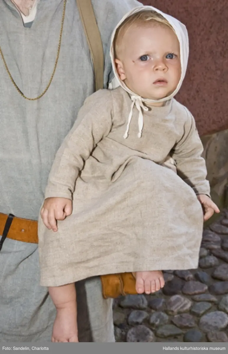 Baby klädd i medeltidskläder.