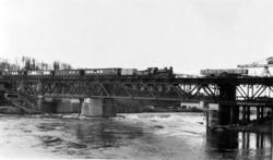 Damplokomotiv med persontog på bru over Sarpsfossen, trolig 