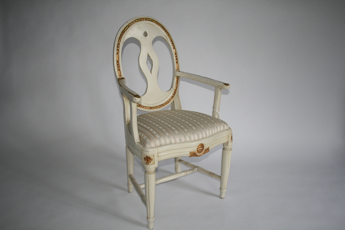 Armstol, hvitmalt med forgylt dekor, oval rygg.
Louis Seize-stil.
En av 6 stoler.