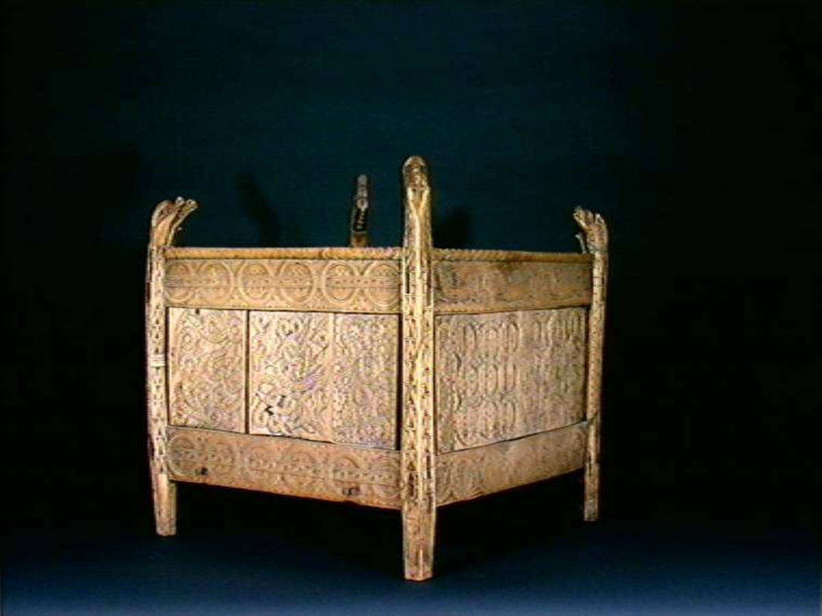 Fire søyler med skåret dyrehode-ornamentikk, sammenføyet med tverrbord og fyllinger. Bunn er åpen foruten to tverrstaver. Hele utsiden er rikt dekorert med utskåret dyr og ranker.