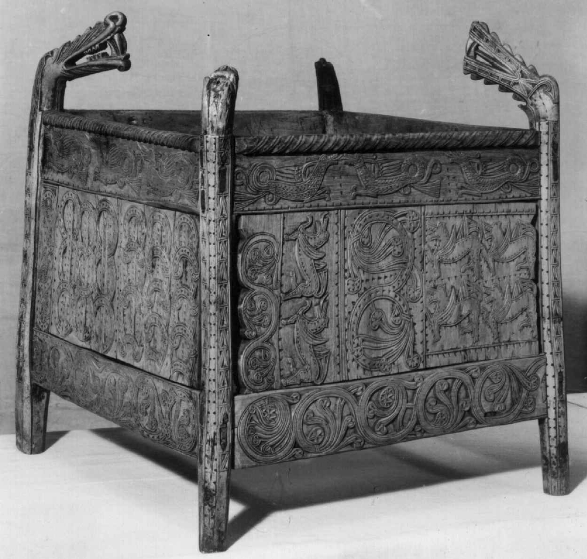 Fire søyler med skåret dyrehode-ornamentikk, sammenføyet med tverrbord og fyllinger. Bunn er åpen foruten to tverrstaver. Hele utsiden er rikt dekorert med utskåret dyr og ranker.