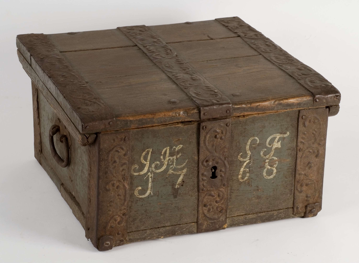 Ferdaskrin i tre med brede jernbeslag i dreven dekor.