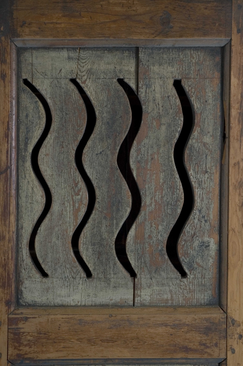 Melkeskap med en dør med fire gjennombrutte bølgende linjer og fire hyller invendig. Dekorert med blomstermotiver, rosemalt.
