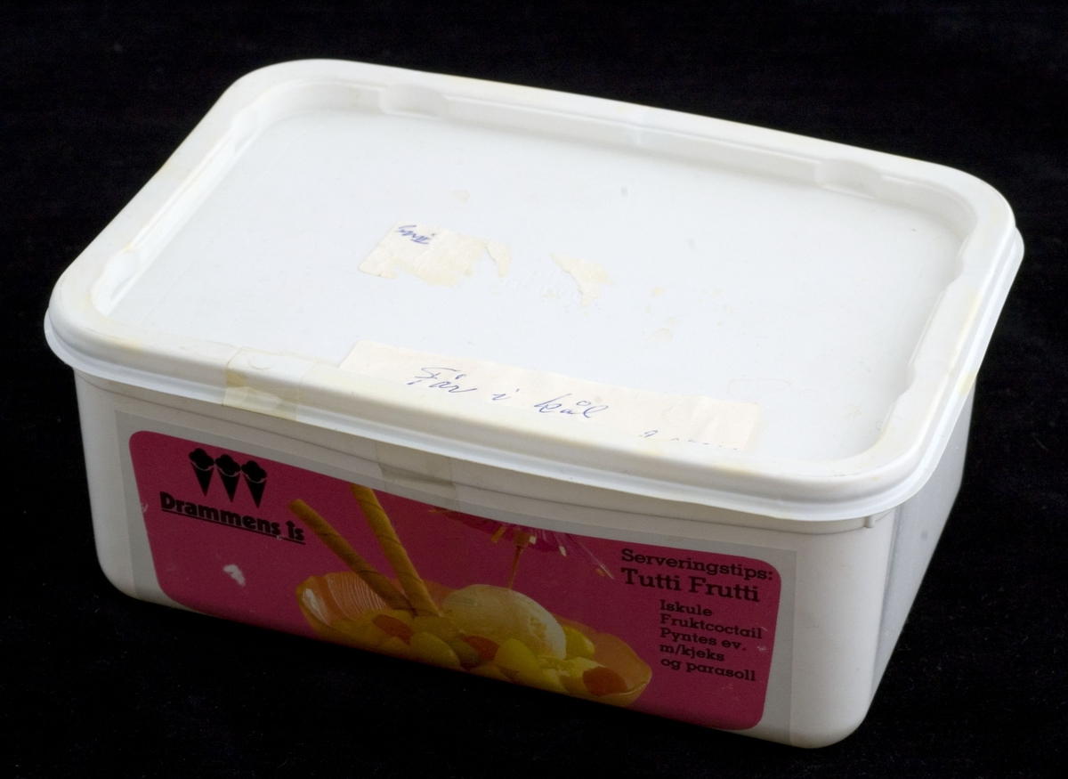 Emballasje til Drammens is. Senere brukt til å fryse ned mat i. Hvit, rektangulær plastboks med lokk. Etikett med varedeklarasjon og serveringstips på selve boksen. Sekundær påklistret merkelapp på lokket.