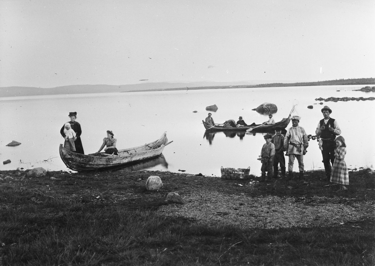 Persongruppe ved elvebredden og i to elvebåter, Svanvik, Salmijarvi, Sør-Varanger, Finnmark, 1890-årene.